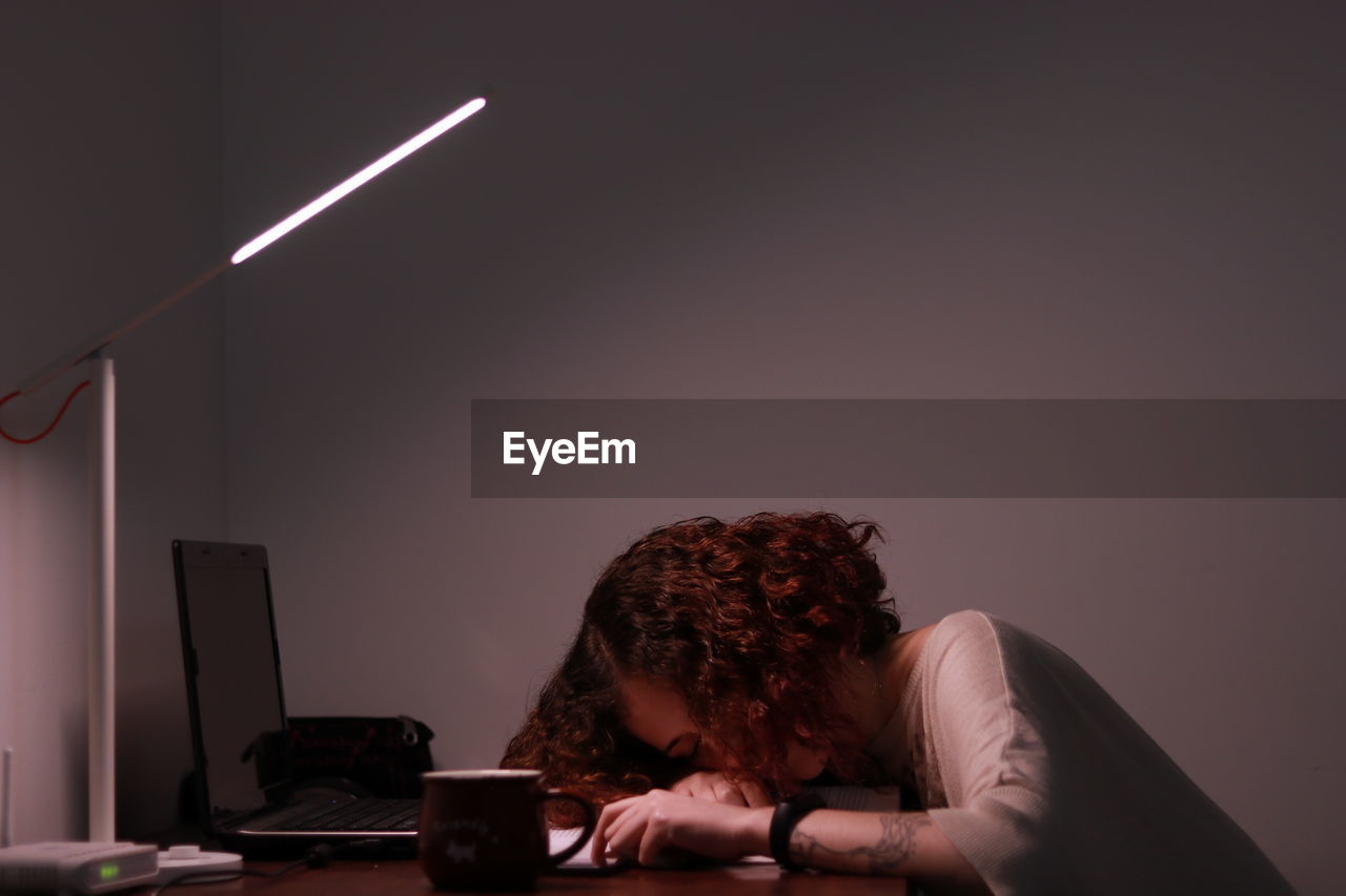 Woman leaning on table by laptop