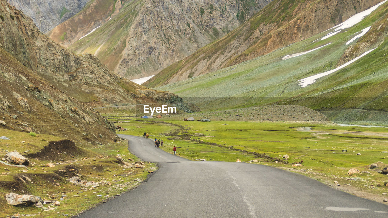 ROAD AMIDST GREEN LAND