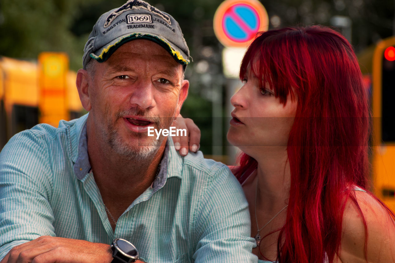 Close-up portrait of mature man with daughter outdoors