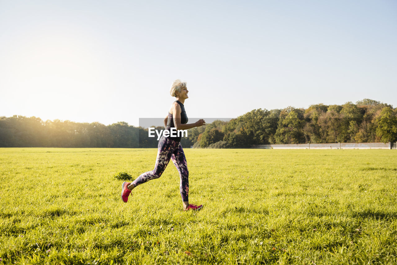 Senior woman running on rural meadow