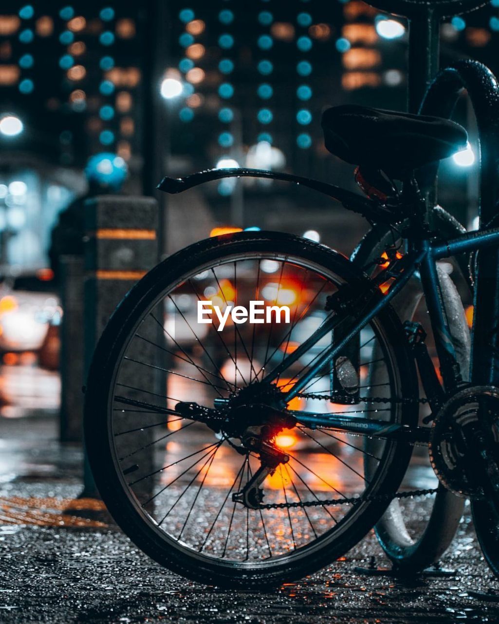 Close-up of bicycle parked on street at night