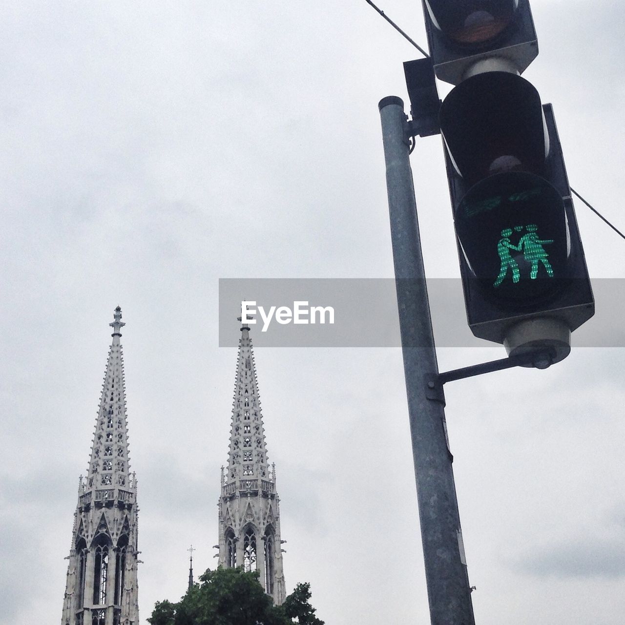 Low angle view of road signal by votive church against sky