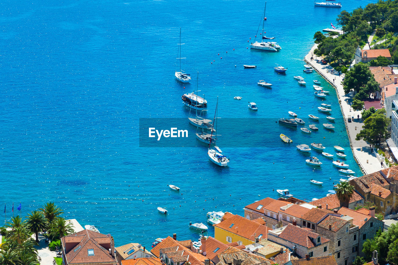 HIGH ANGLE VIEW OF SAILBOATS SAILING IN SEA