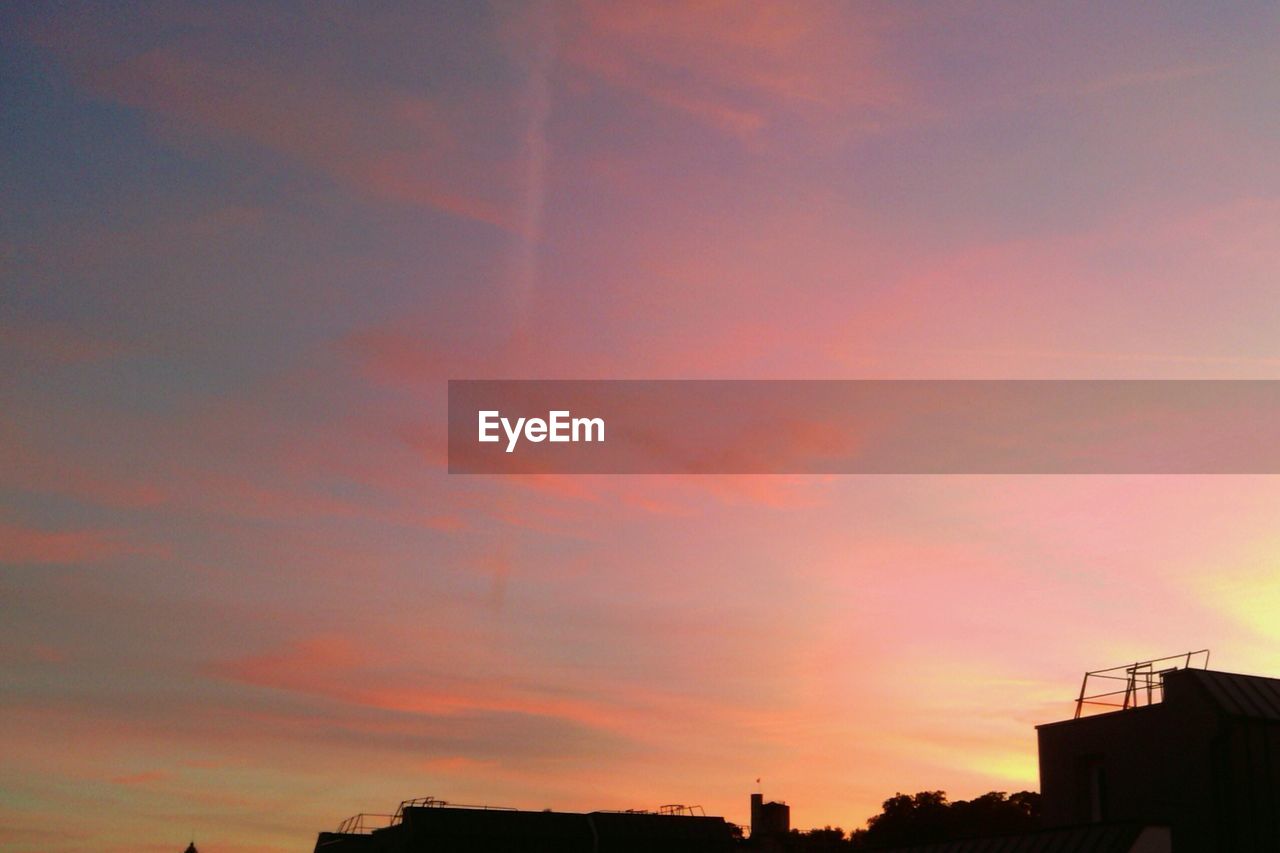 LOW ANGLE VIEW OF BUILDINGS AGAINST SKY AT SUNSET