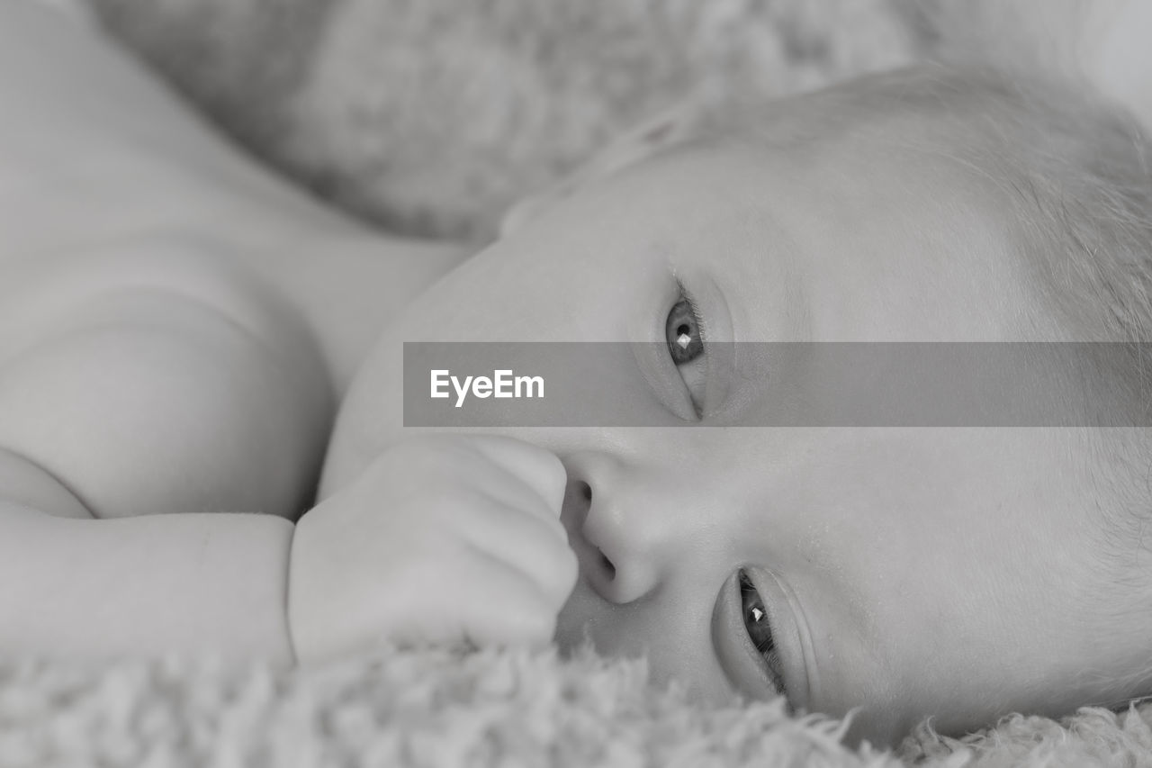 CLOSE-UP PORTRAIT OF CUTE BABY LYING ON BED