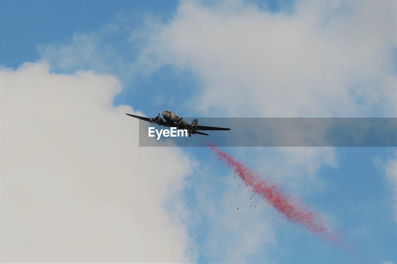 Low angle view of airplane flying against sky