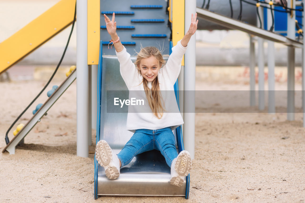 Portrait of girl sliding in playground