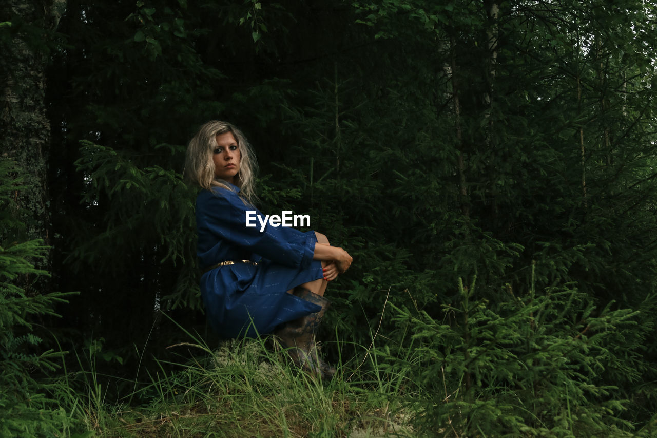 Girl in a blue dress on the background of the forest