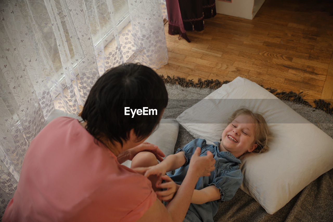 high angle view of mother and daughter sitting at home