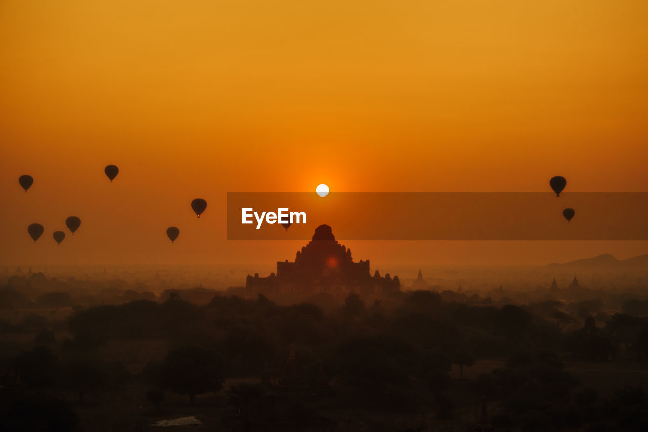 SILHOUETTE OF HOT AIR BALLOONS IN SKY AT SUNSET