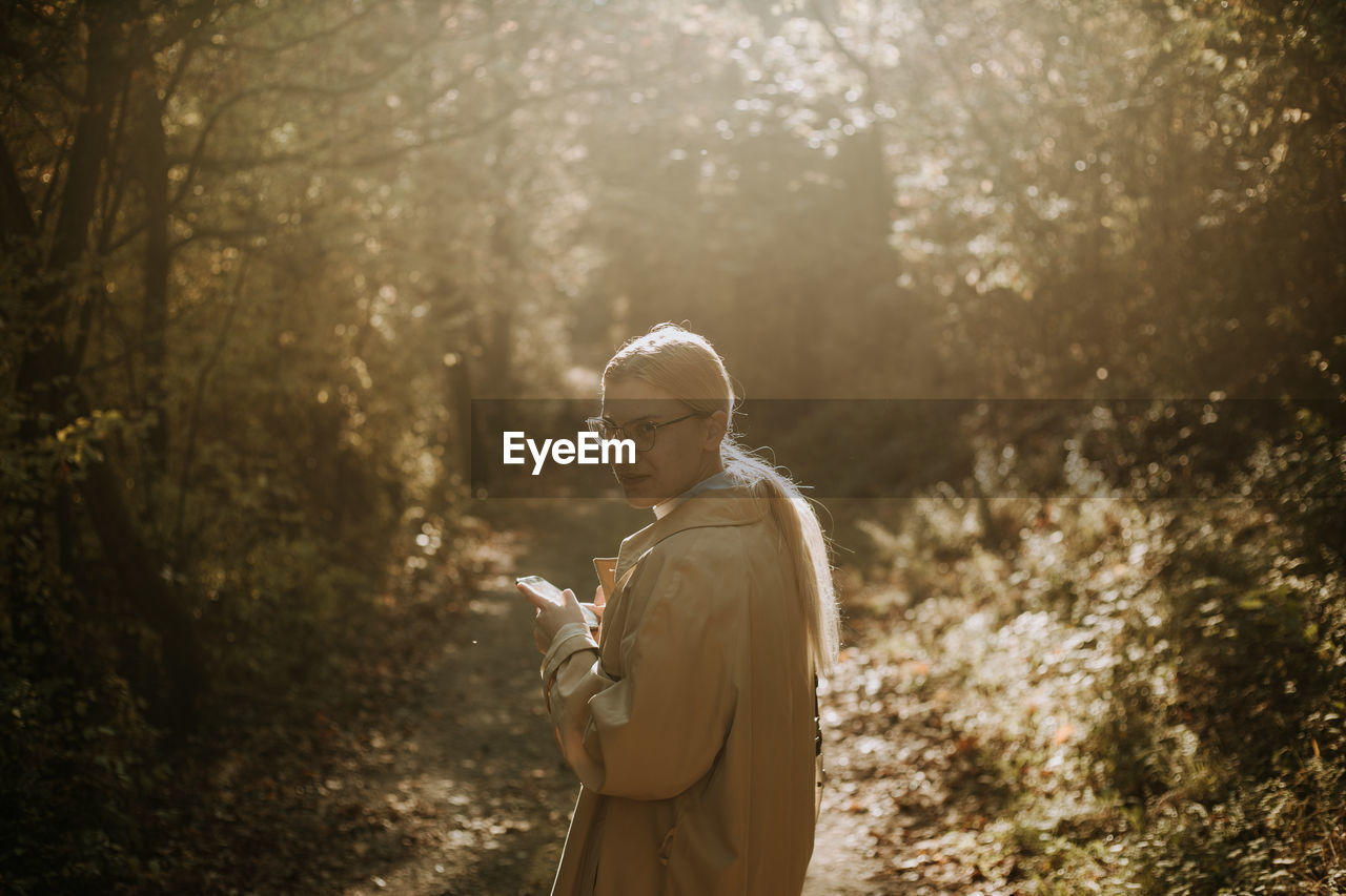 A young woman walking in the woods during autumn