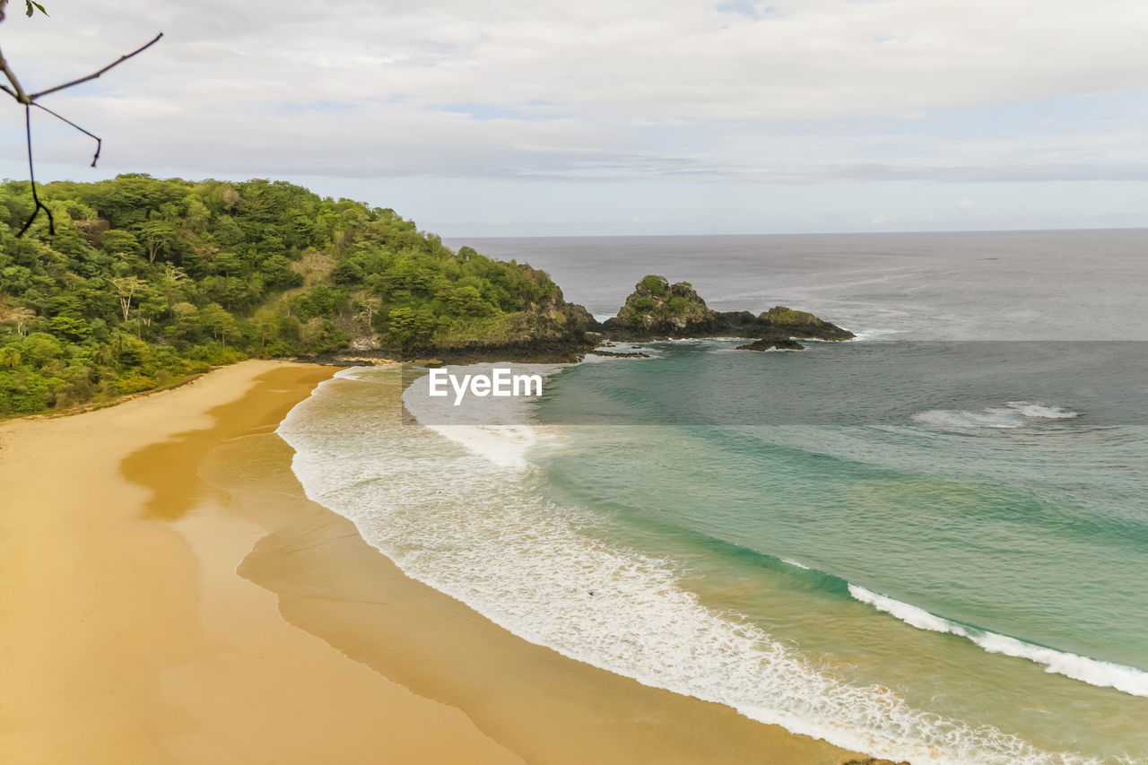 Scenic view of beach against cloudy sky