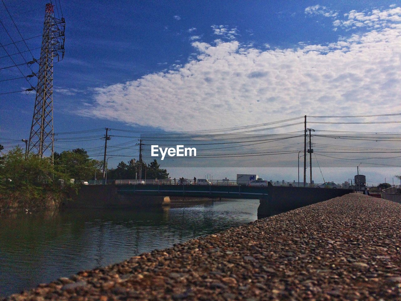 Electricity pylon against cloudy sky