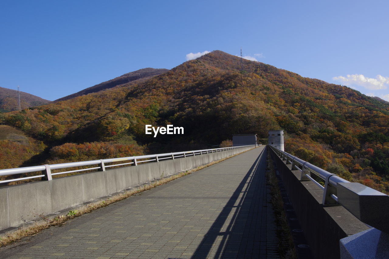 FOOTBRIDGE OVER MOUNTAIN AGAINST SKY