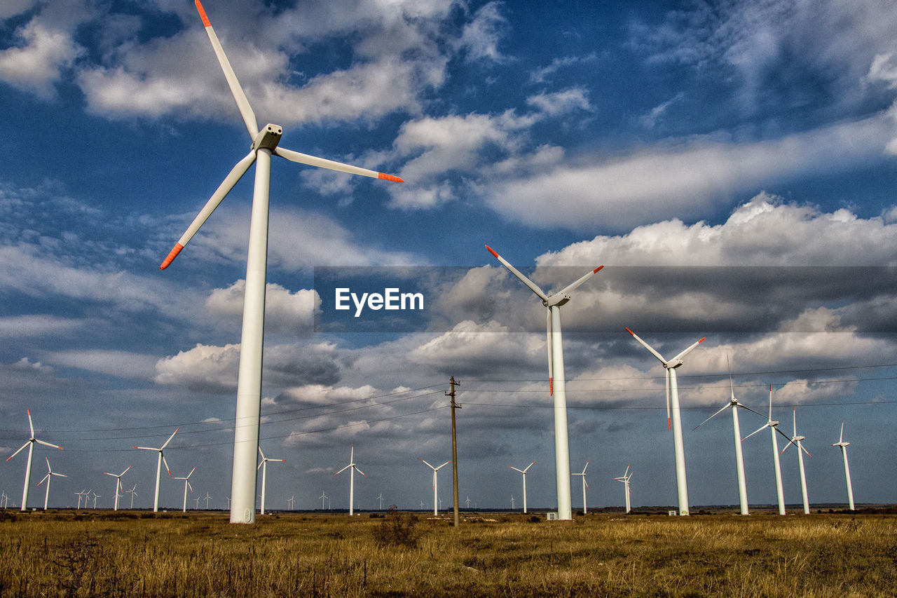 WIND TURBINE ON FIELD AGAINST SKY