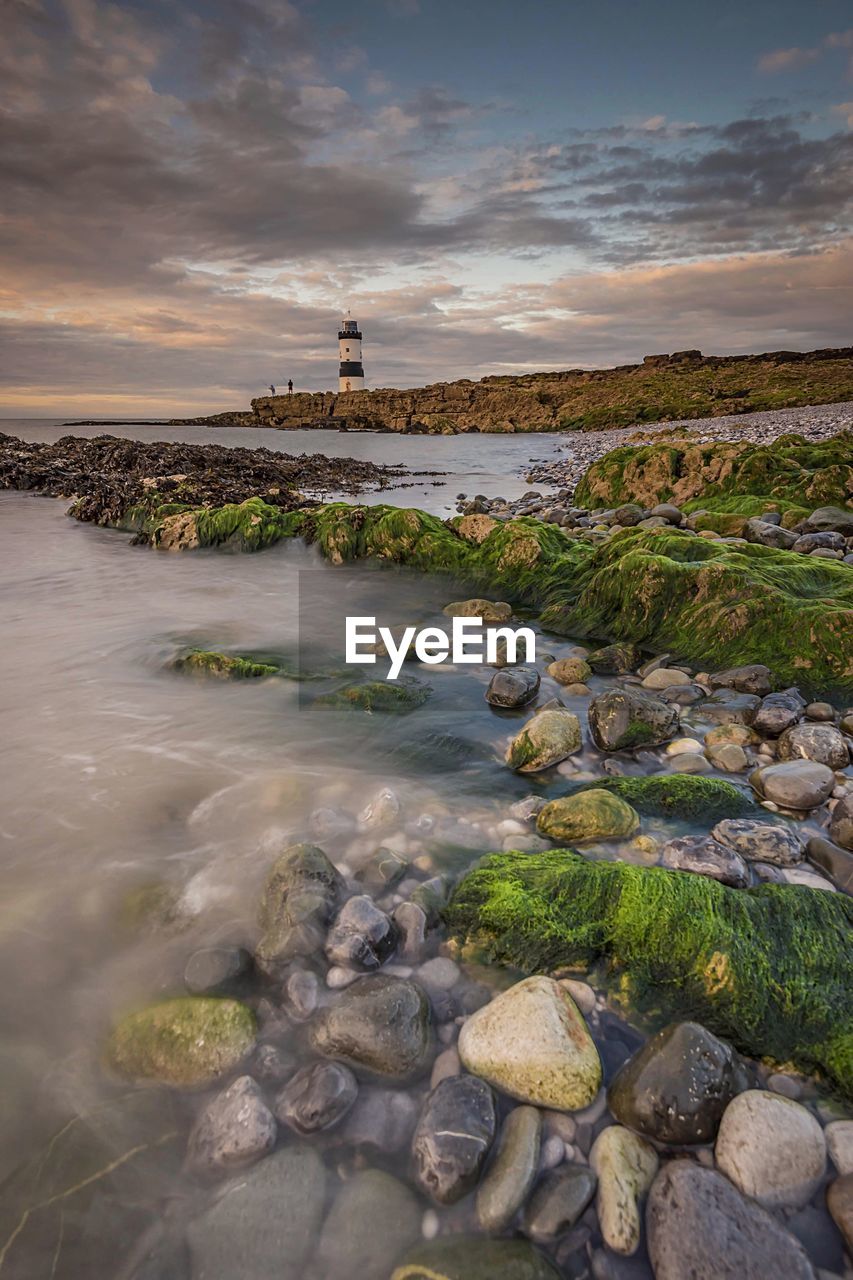 Scenic view of sea against cloudy sky during sunset