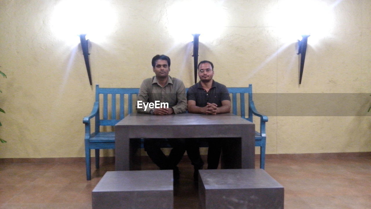 YOUNG MEN SITTING IN CORRIDOR