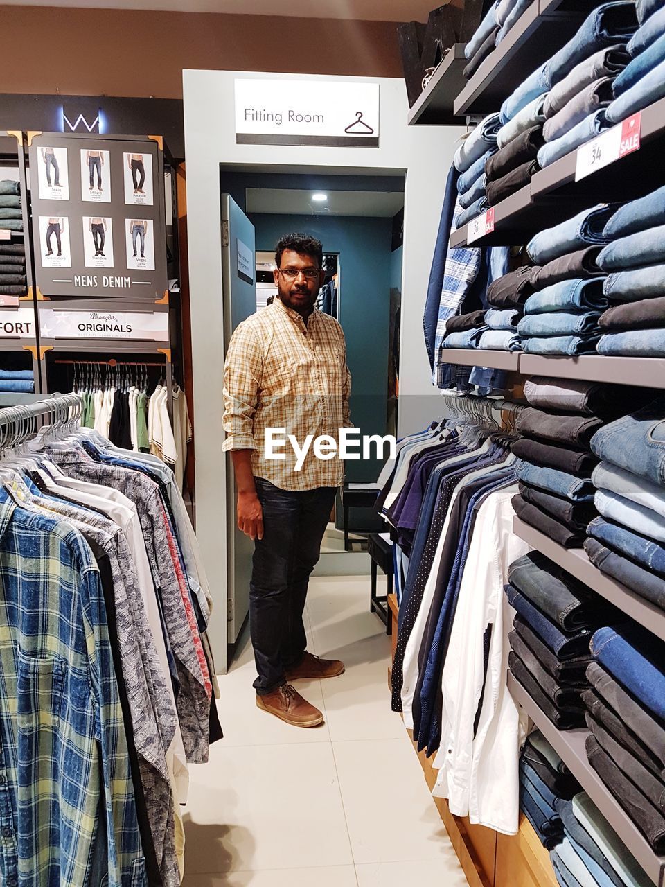 REAR VIEW OF MAN LOOKING AT STORE IN SHOP