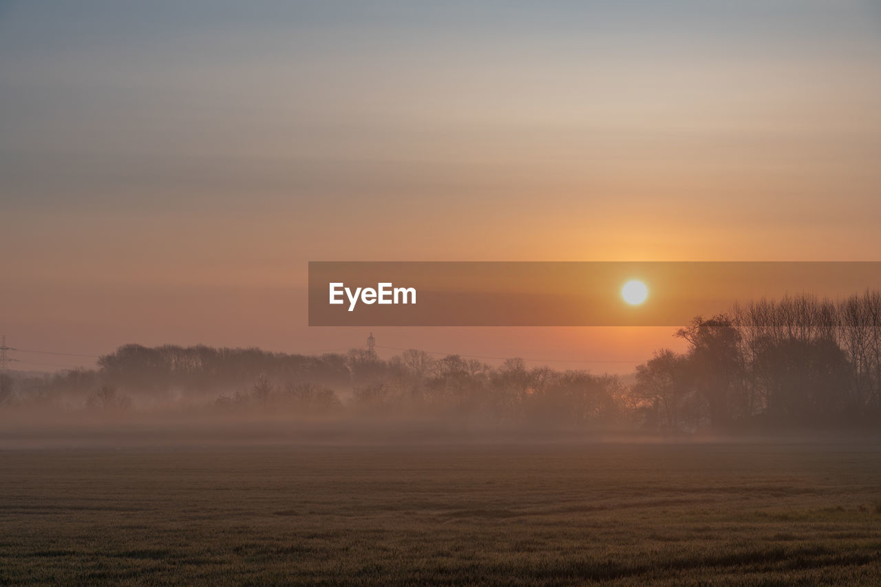 Scenic view of field against sky during sunset