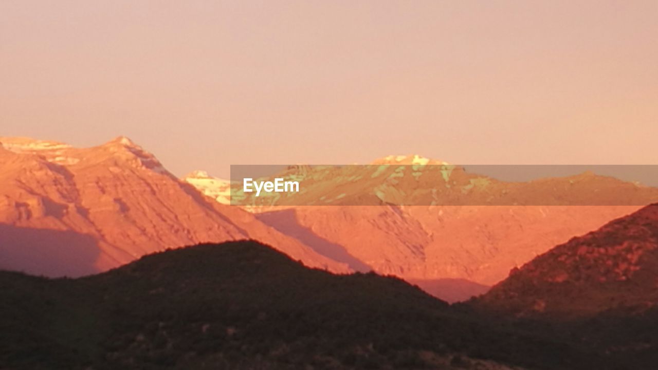 SCENIC VIEW OF MOUNTAINS AGAINST SKY DURING SUNRISE