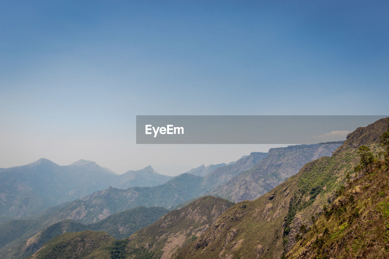 Scenic view of mountains against clear blue sky