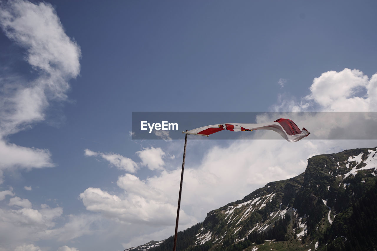 LOW ANGLE VIEW OF FLAGS AGAINST MOUNTAIN RANGE