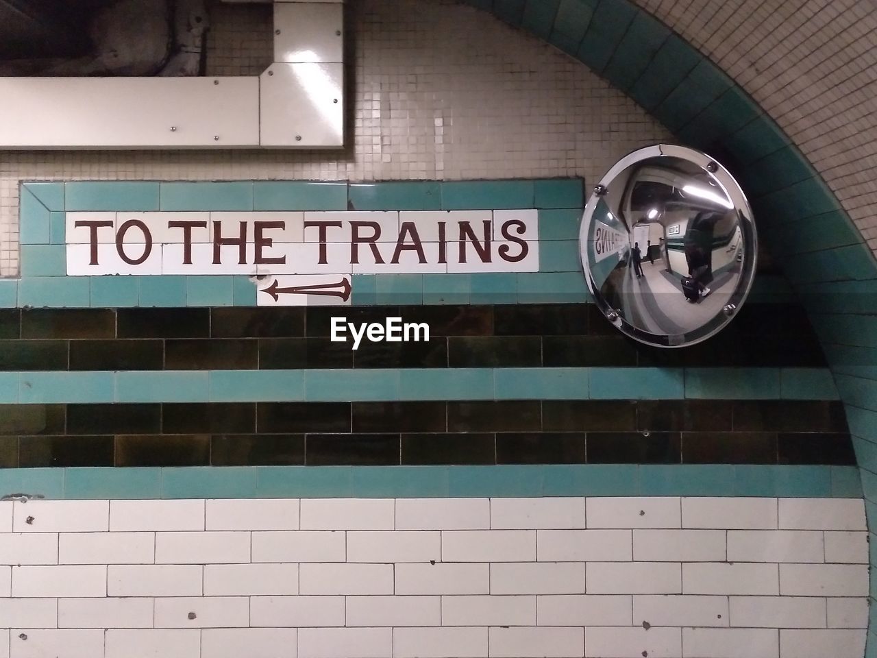 LOW ANGLE VIEW OF TEXT ON WALL WITH TILED FLOOR