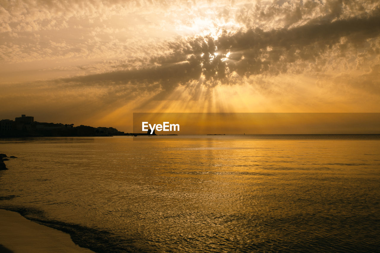 Dramatic sunset over the sea in cloudy sky, beautiful nature scene, horizon over water.