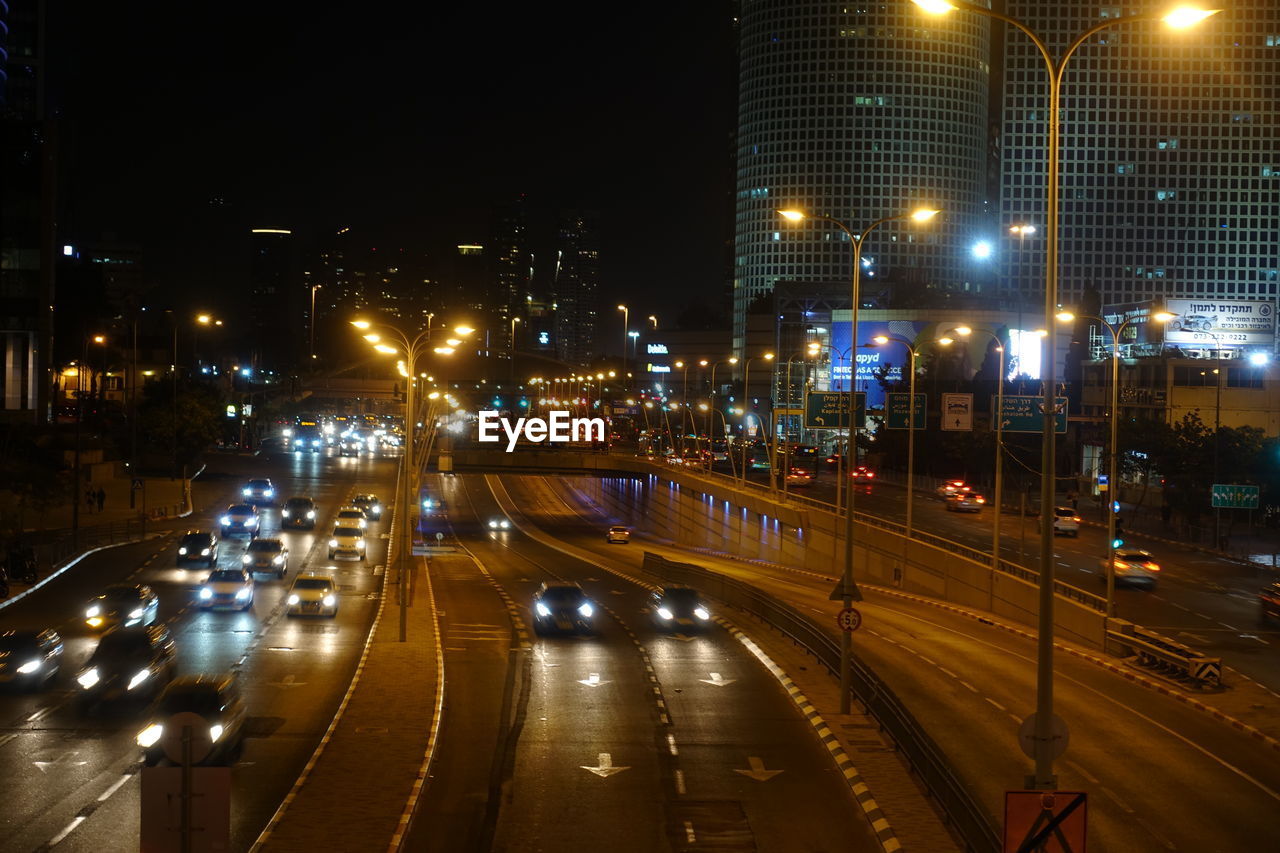 HIGH ANGLE VIEW OF CARS ON CITY STREET AT NIGHT