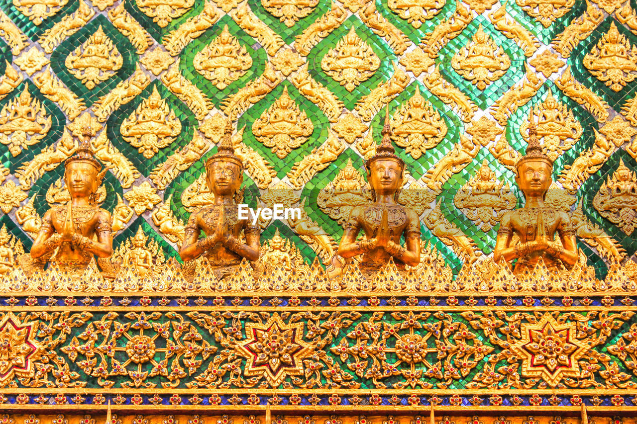 LOW ANGLE VIEW OF BUDDHA STATUE ON BUILDING