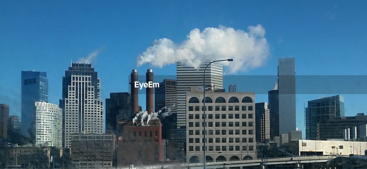 Panoramic view of cityscape against blue sky