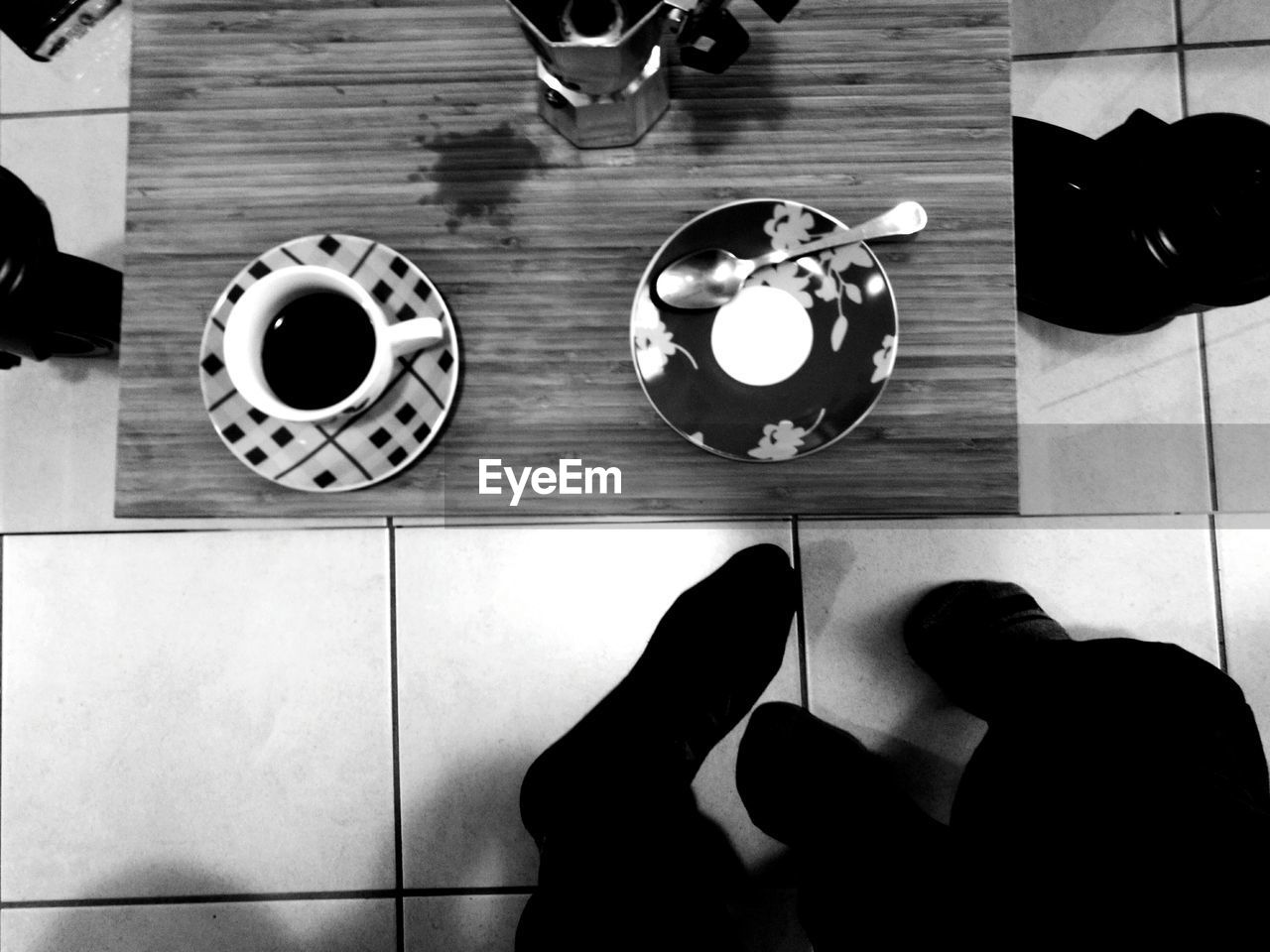 LOW SECTION OF WOMAN STANDING BY COFFEE CUP WITH TEXT ON TABLE