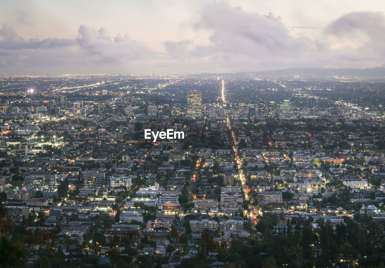 Aerial view of illuminated cityscape against sky at dusk