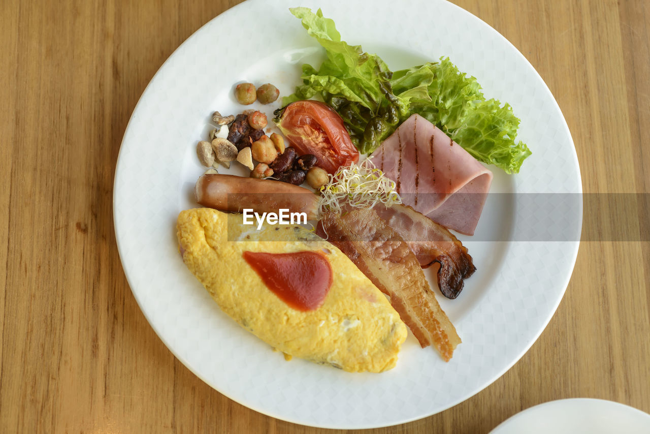 High angle view of breakfast in plate on wooden table