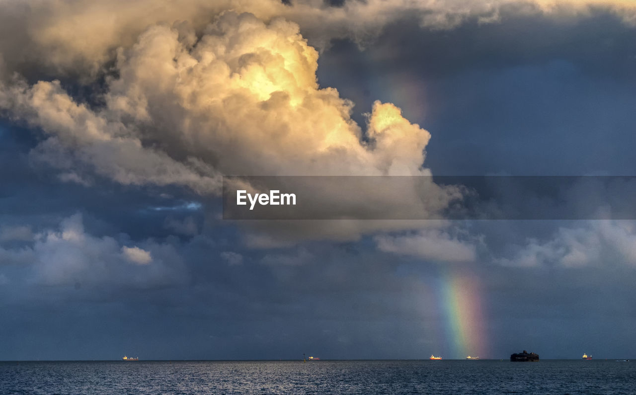 Scenic view of rainbow over sea against sky