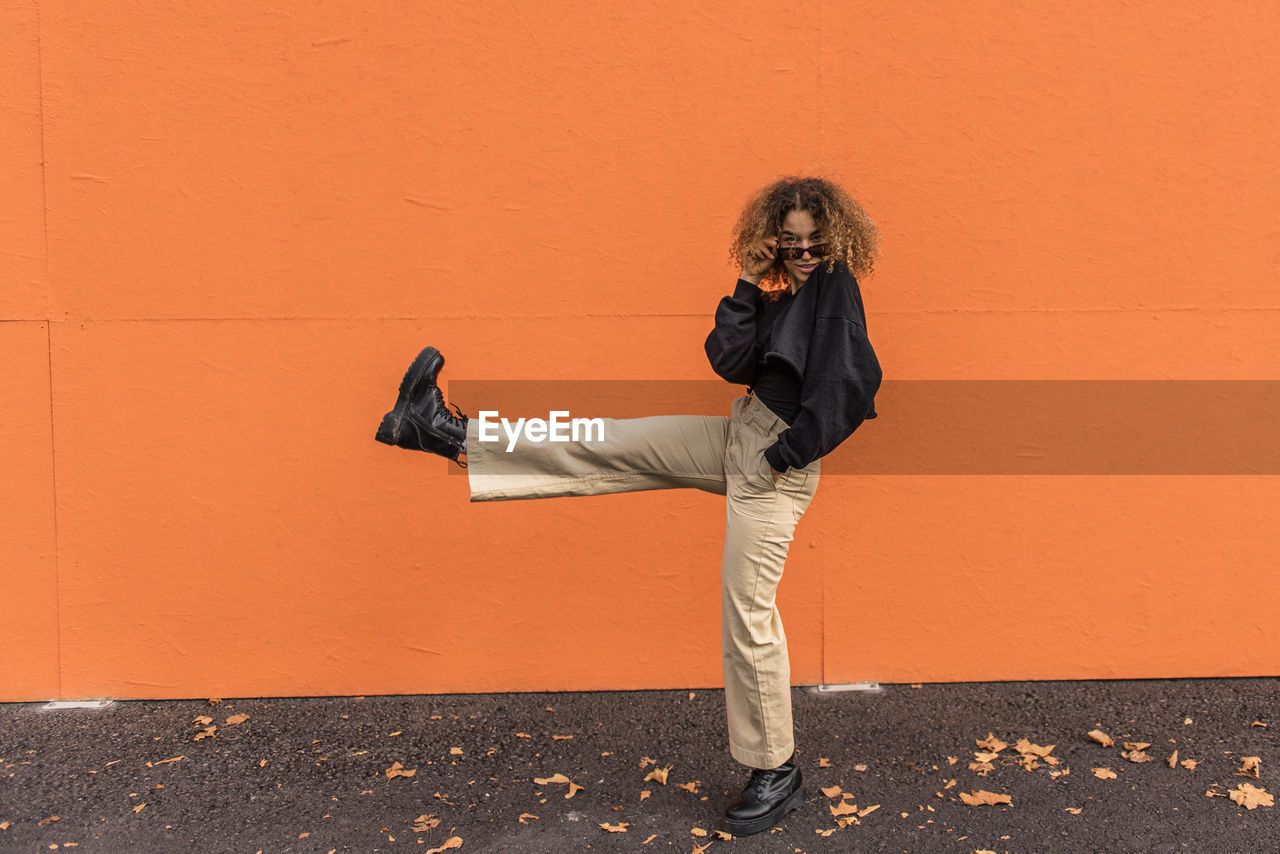 Woman dancing while standing on footpath