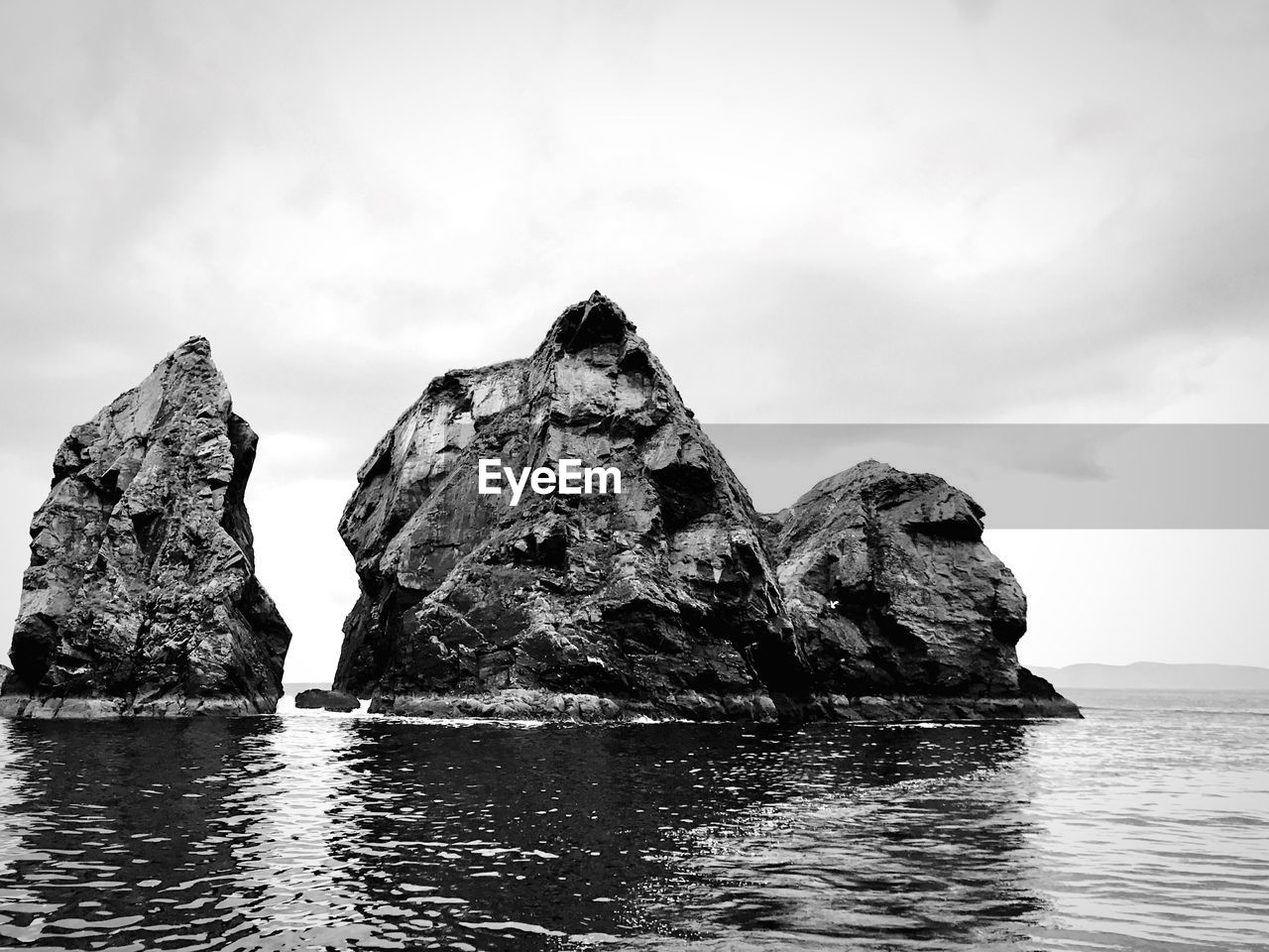 Rock formation in sea against sky