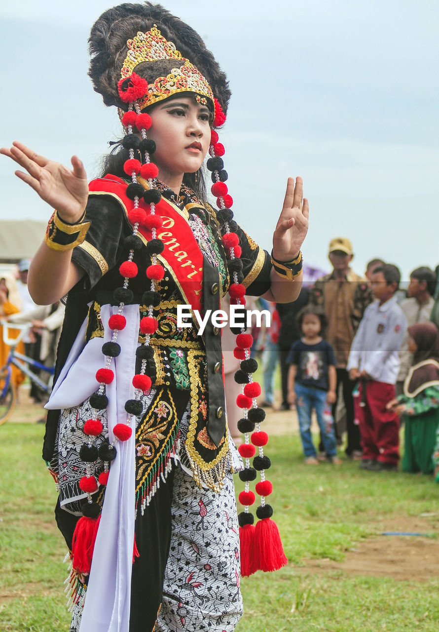 Friends wearing traditional clothing against sky