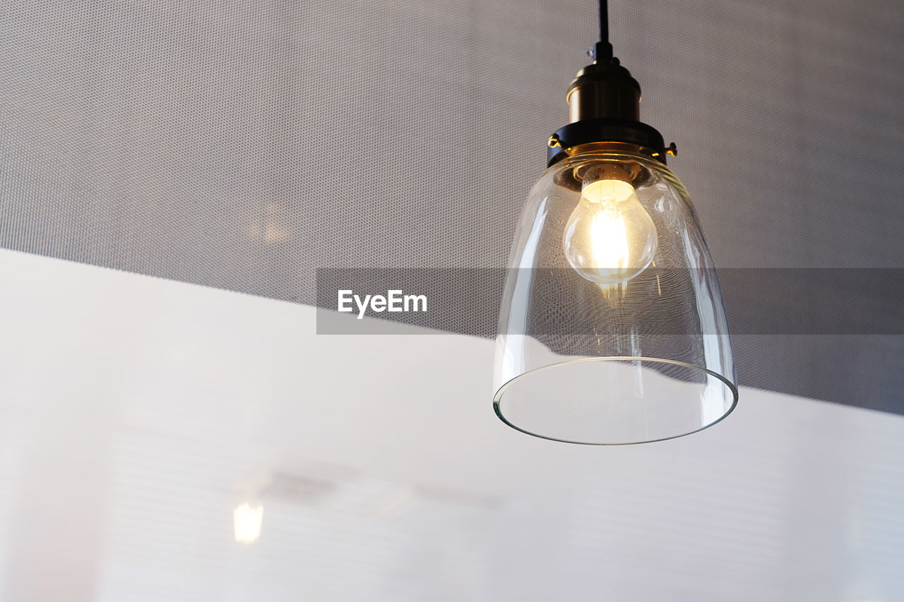 Low angle view of illuminated pendant light hanging from ceiling