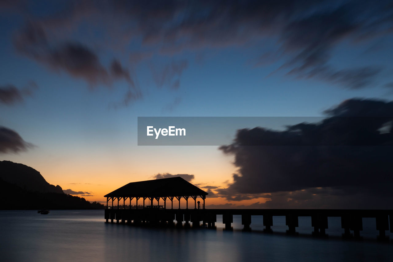 SILHOUETTE PIER OVER SEA AGAINST SKY DURING SUNSET