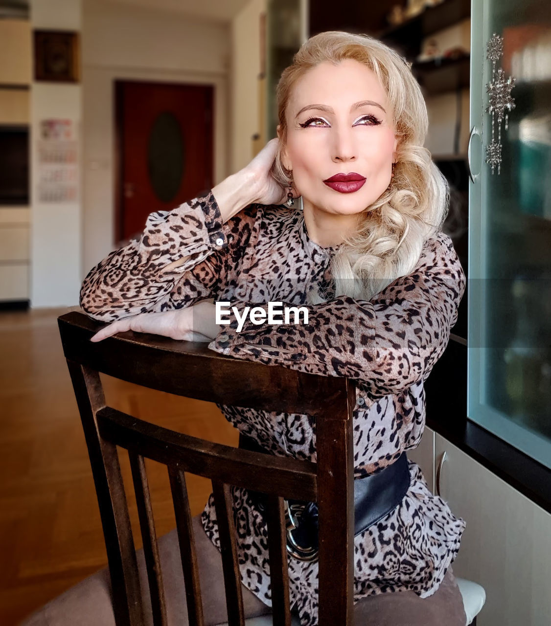 Beautiful mature woman sitting on chair at home