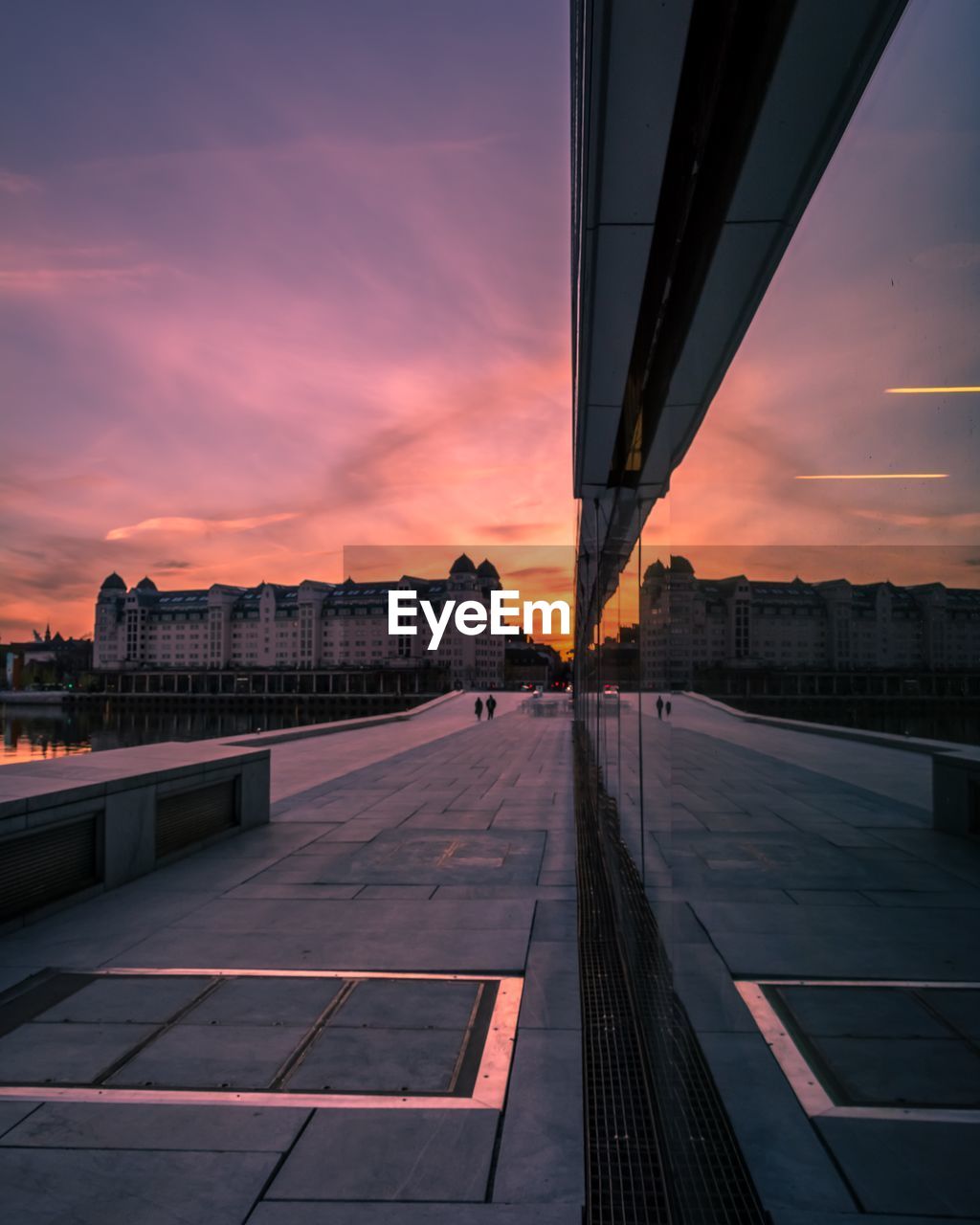 Bridge in city against sky during sunset