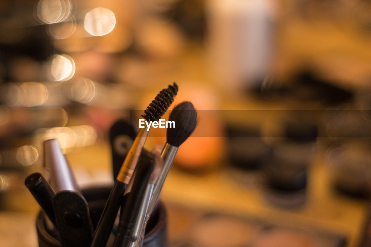 Close-up of make-up brushes in container on table