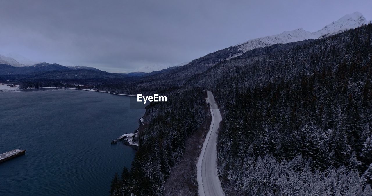 Scenic view of river by mountains against sky