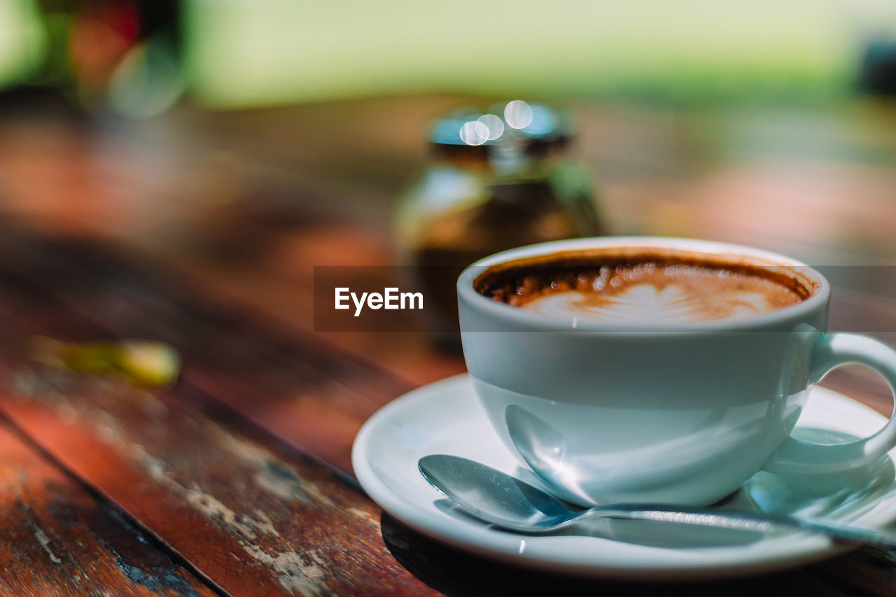 CLOSE-UP OF COFFEE CUP ON TABLE WITH SPOON