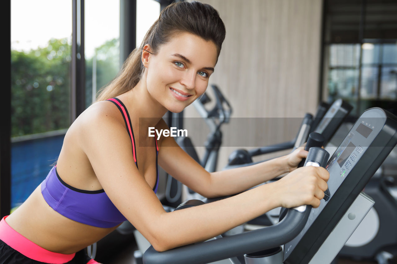 Portrait of smiling woman exercising at gym