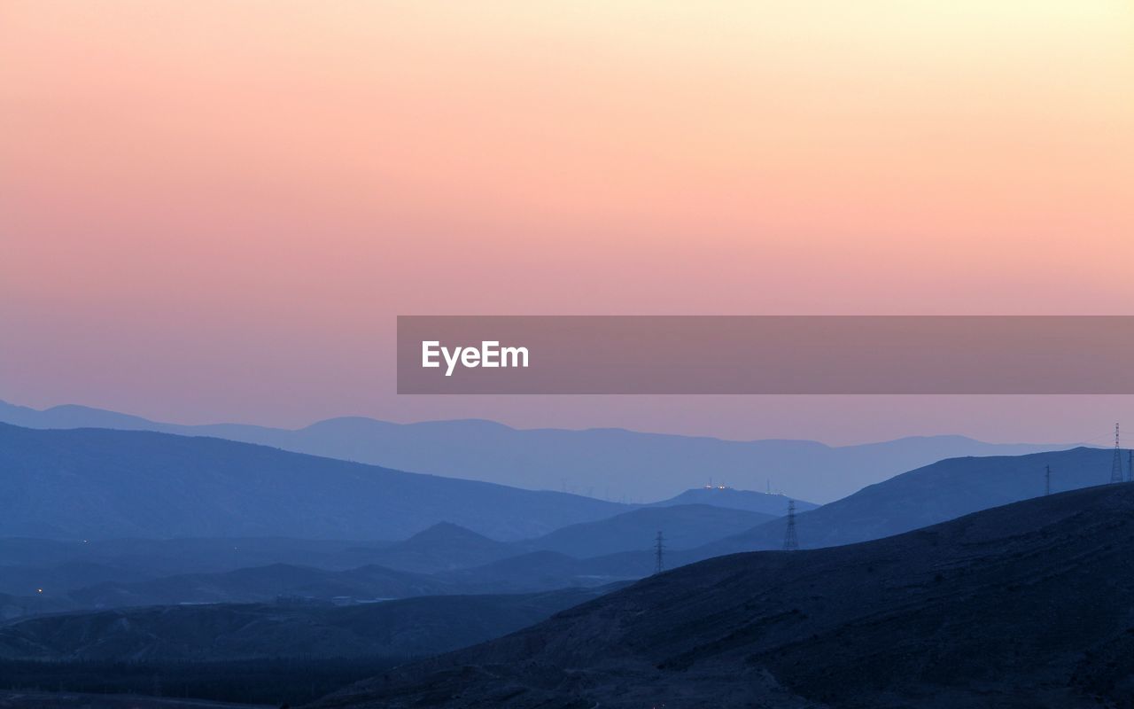 Scenic view of mountains against clear sky during sunset