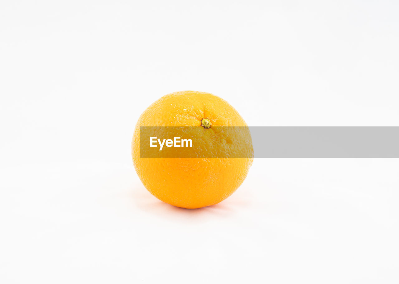 CLOSE-UP OF ORANGE SLICE AGAINST WHITE BACKGROUND