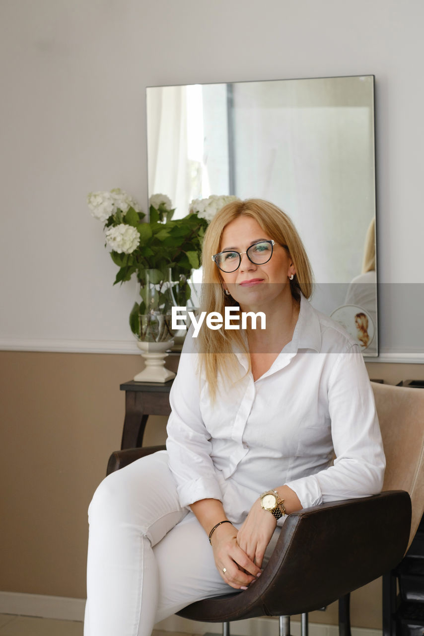 Beauty salon worker. middle-aged woman hairdresser waiting for client. smiling small beauty salon