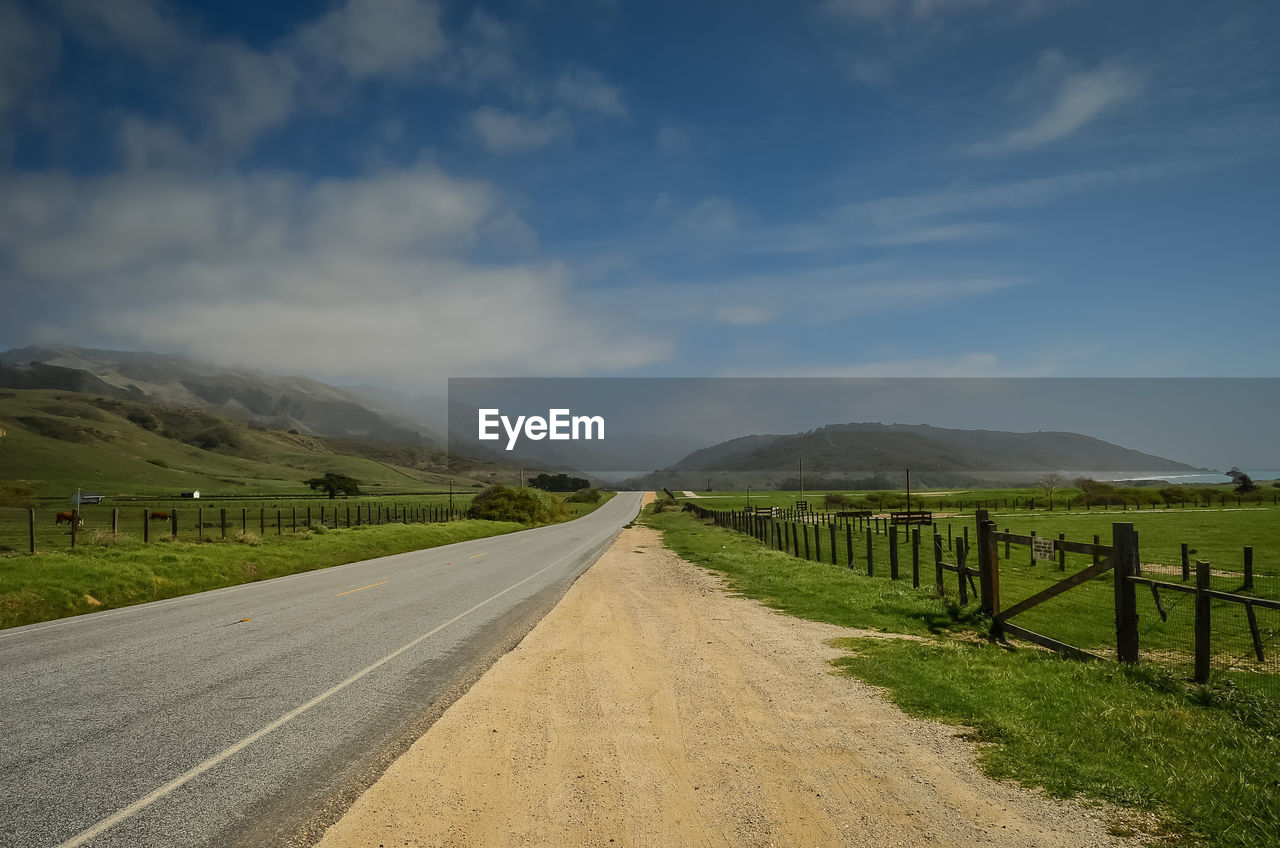 Empty road along countryside landscape